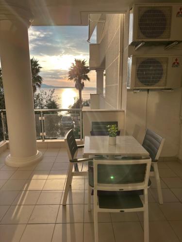 - une table à manger et des chaises avec vue sur l'océan dans l'établissement White Coast Apartment, à Saranda