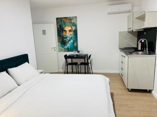 sypialnia z białym łóżkiem i małą kuchnią w obiekcie Viva Apartments w mieście Përmet