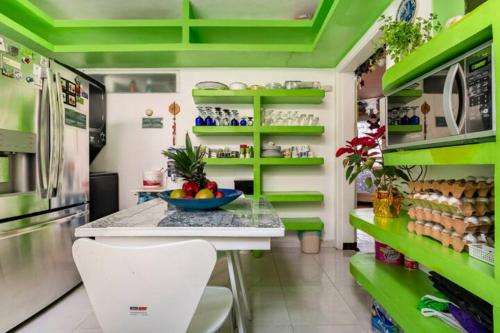 eine grün-weiße Küche mit einer Theke und einem Kühlschrank in der Unterkunft Casa ITZAE B&B- Lincoln Park dog friendly in Mexiko-Stadt