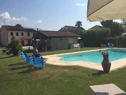 - une piscine avec 2 chaises et un vase dans la cour dans l'établissement Rustico del Chiasso, à Capannori