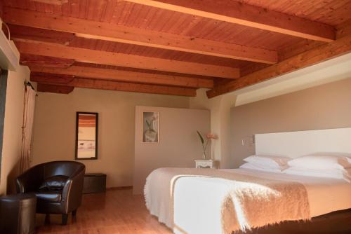 a bedroom with a bed and a chair at El Secanet in Algimia de Alfara