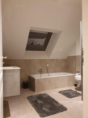 a bathroom with a bath tub and a sink at Fewo RoBBe in Wangerland