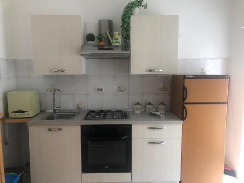 a kitchen with a stove and a sink and a refrigerator at Casa Petralia in Petralia Sottana