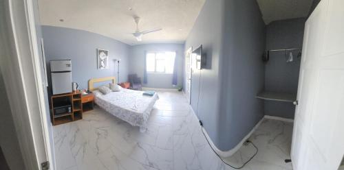 ShkyBlue Suites في كرايست تشيرش: غرفة نوم بسرير وأرضية بيضاء من البلاط