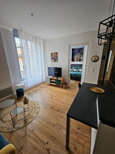 - un salon avec un comptoir noir et du parquet dans l'établissement Urban Jungle - centre historique - calme absolu, à Pau