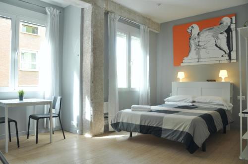 1 dormitorio con cama, mesa y escritorio en La Casa Verde - Ruzafa en Valencia