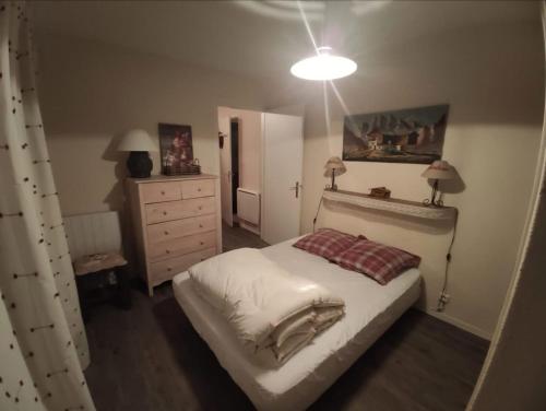 - une chambre avec un lit, une commode et une lampe dans l'établissement Superbe appartement à Orcières merlette, à Orcières
