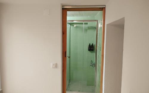 a glass shower with a glass door in a bathroom at O Refúgio do Pim in Horta