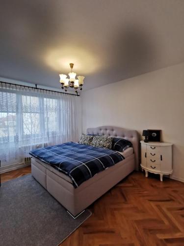 a bedroom with a bed and a large window at PRIMA Apartmán in Košice