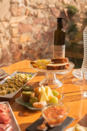 a table with a bottle of wine and plates of food at El Secanet in Algimia de Alfara