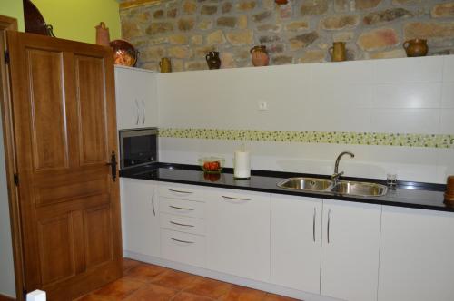 een keuken met een wastafel en een magnetron bij La Casa del Rio - La Lobera Casa Rural in Molinos de Razón