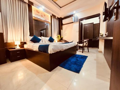 a bedroom with a large bed and a blue rug at Hotel Ramawati - A Luxury Hotel In Haridwar in Haridwār