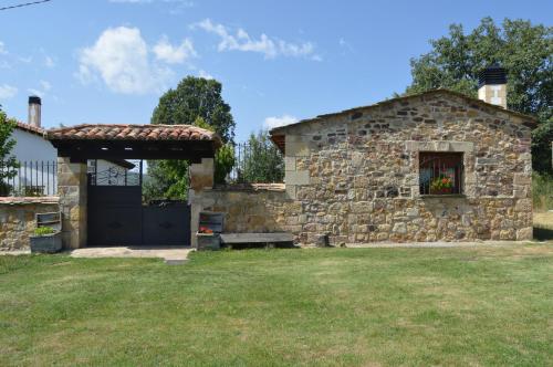 une maison en pierre avec un portail et un mur en pierre dans l'établissement La Casa del Rio - La Lobera Casa Rural, à Molinos de Razón