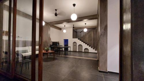 an open hallway with a dining room and a staircase at Kave Hotels - Pondicherry in Puducherry