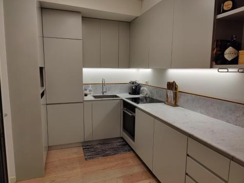 een keuken met witte kasten en een wastafel bij Cozy Apartment Brera in Milaan