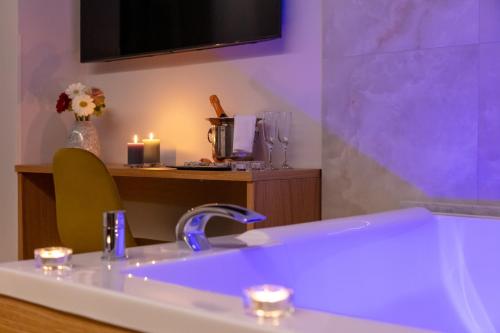 a bathroom with a sink and a tv and candles at MAIN - Duomo in Naples