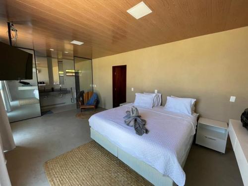 1 dormitorio con 1 cama blanca grande y baño en Luxo Pé na Areia na Rota Milagres, en Tatuamunha