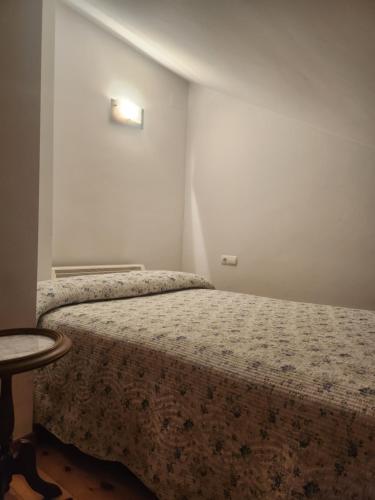 a small bedroom with a bed and a table at La casa sobre el rÍo in Cuenca