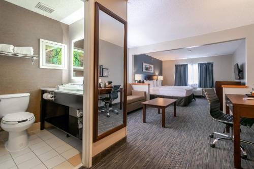 a hotel room with a bed and a bathroom at Wingate by Wyndham Great Falls in Great Falls