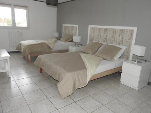 - deux lits dans une chambre avec deux tables et lampes dans l'établissement Gîte Lavalette09 Ardèche et Cèze, à Saint-Christol-de-Rodières