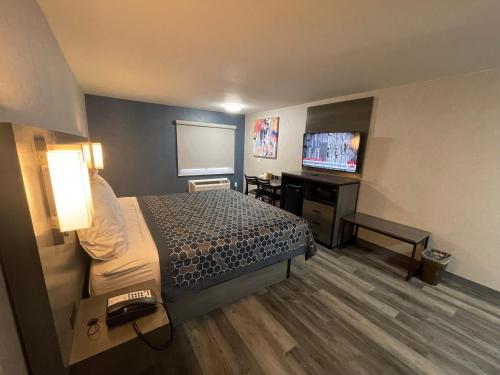 ein Hotelzimmer mit einem Bett und einem Flachbild-TV in der Unterkunft The Wayne Inn in Wayne