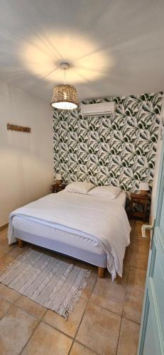 a bedroom with a white bed with a wall at Villa 78 Alba Rossa Piscine chauffée et Plage de Cupabia in Serra-di-Ferro