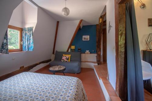 a bedroom with a bed and a couch in a room at Le prieuré des fontaines in Les Préaux