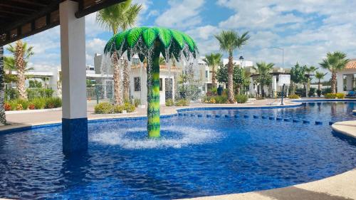 a palm tree in the middle of a swimming pool at Casa Mazatlán, alberca, baño y clima en cada habitacion in Mazatlán