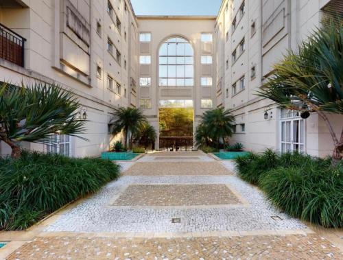 a courtyard in a building with palm trees at Excelente Apto ao Lado do Hospital Albert Einstein Faculdade de Medicina Einstein e Estádio Morumbi com Garagem in Sao Paulo