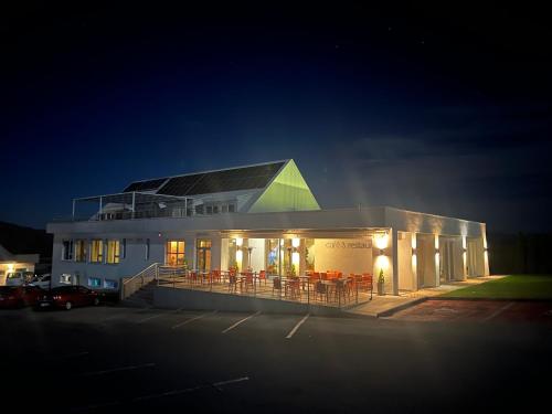 a building with tables and chairs in a parking lot at night at Penzión Aqua Maria in Veľaty