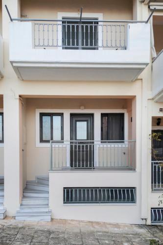 a white house with stairs and a balcony at Rincon De Luz in Kyparissia