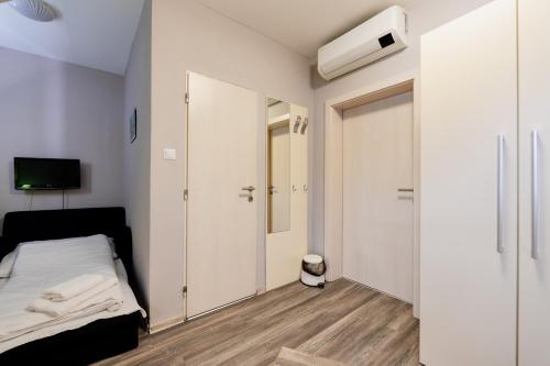 a small bedroom with a bed and a closet at Penzión Aqua Maria in Veľaty