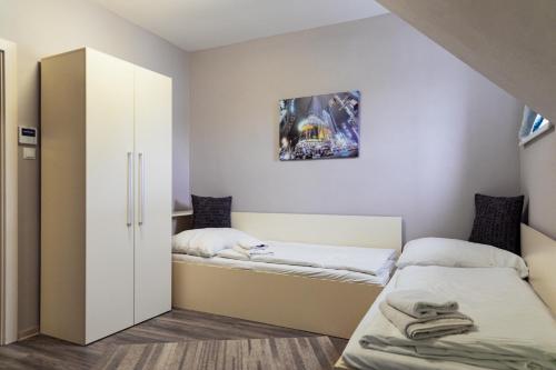 a bedroom with two beds and a closet at Penzión Aqua Maria in Veľaty