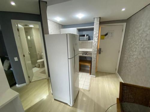 a kitchen with a white refrigerator in a room at Flat Moema Jamaris in São Paulo