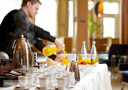 a man is making a drink on a table at Lenkerhof gourmet spa resort - Relais & Châteaux in Lenk