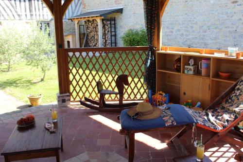d'une terrasse couverte avec une table et un hamac. dans l'établissement La maison de Mariette, à Villers-sur-Mer