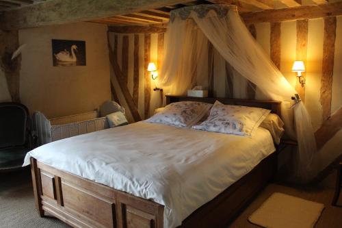 une chambre avec un lit à baldaquin dans l'établissement La maison de Mariette, à Villers-sur-Mer