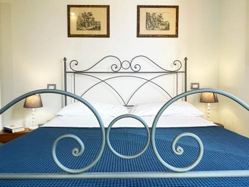 a bedroom with a metal bed with a blue comforter at Oliveta blu in Siena