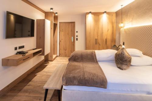 a bedroom with a large bed and a tv at Superior Hotel Post Ischgl in Ischgl