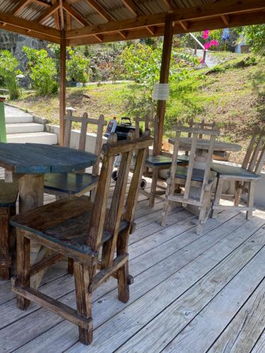 un grupo de mesas y sillas en una terraza de madera en Blue Bamboo cottage Marigot Bay., en Bahía Marigot