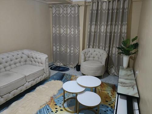 ein Wohnzimmer mit einem Sofa und 2 Tischen in der Unterkunft D.S Apartment in Kakamega