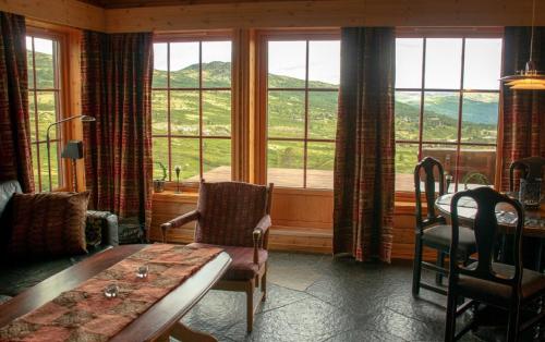 a room with a table and chairs and a large window at Rondane Haukliseter Fjellhotell in Høvringen