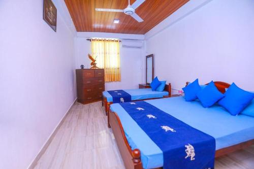 パナドゥラにあるSilverin Rest Apartmentのベッド2台と天井ファン付きの寝室
