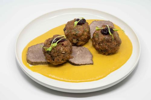 a plate of food with meatballs and sauce at Penzión Aqua Maria in Veľaty