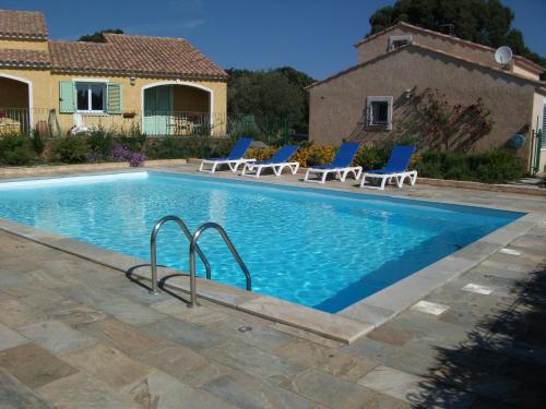 una piscina con sillas y una casa en Gîtes Santa Maria Cap Corse, en Macinaggio