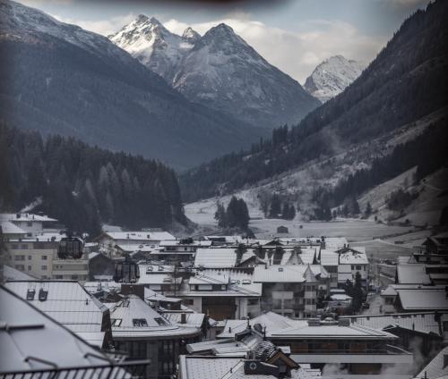 a town with snow covered roofs and mountains at Superior Hotel Post Ischgl in Ischgl
