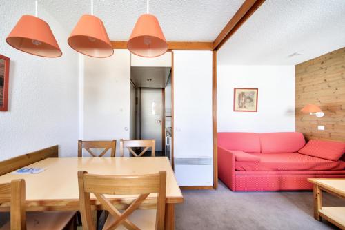 un salon avec un canapé rouge et une table dans l'établissement Résidence Les Chalets des Arolles - maeva Home - Studio 4 Personnes - Confort MAE-5711, à Aime La Plagne