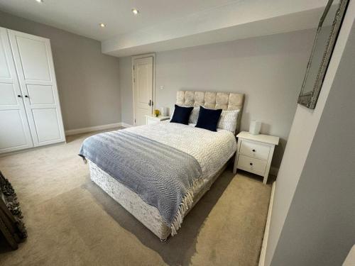 a bedroom with a large bed with blue pillows at Brentford Guest Rooms in Brentford
