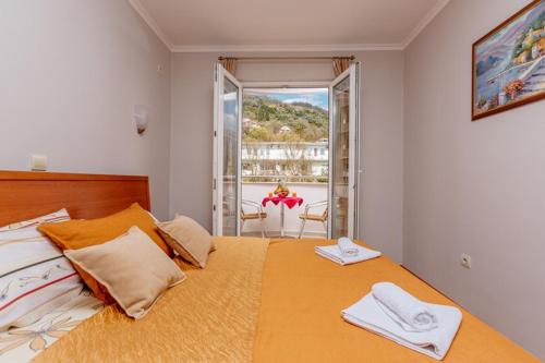 a bedroom with a large bed with two towels on it at Apartments PERPER in Tivat