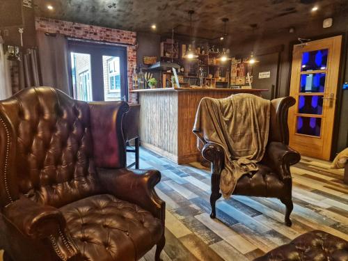 a barber shop with two leather chairs and a chair with a blanket at The Pub, with Private Parking in Bristol